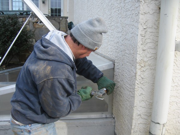 Man working on Installation of Cleargress Door Basement Entrance