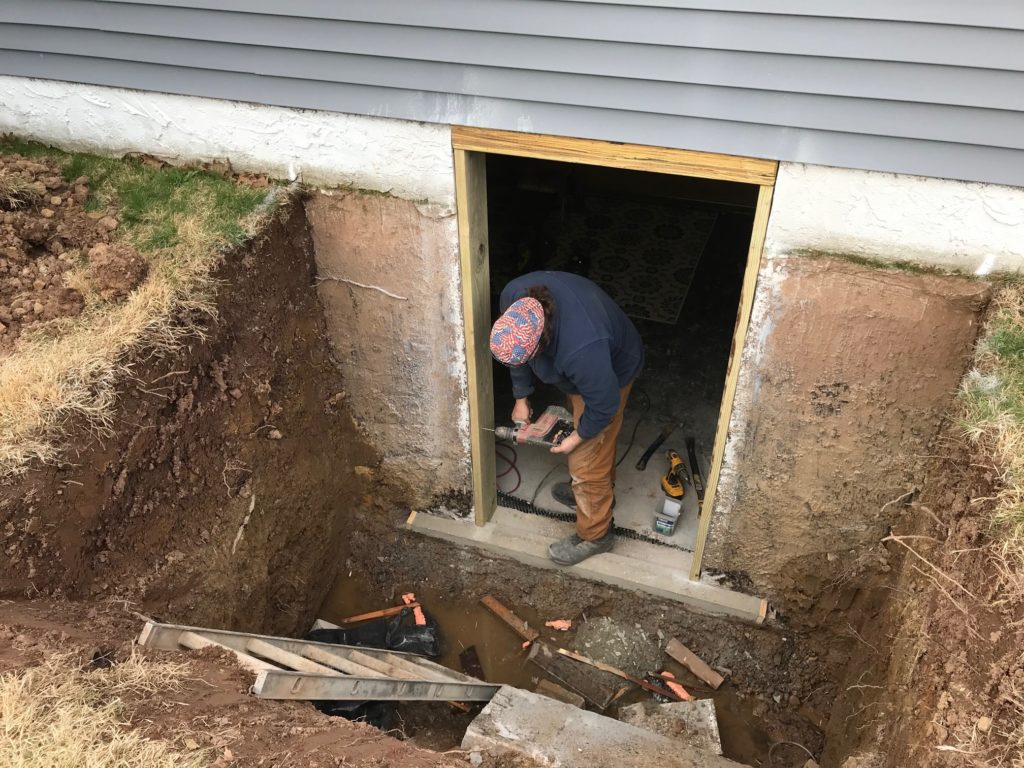 A worker is installing the door for the basement