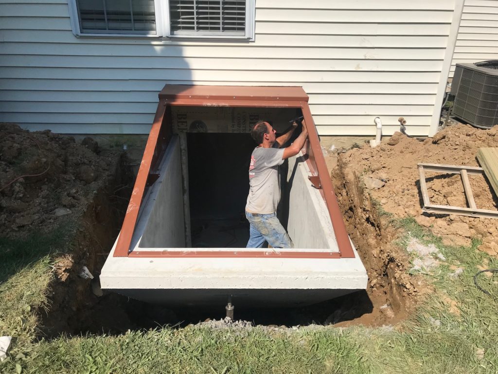A worker is working on building the Bilco® Door for the basement