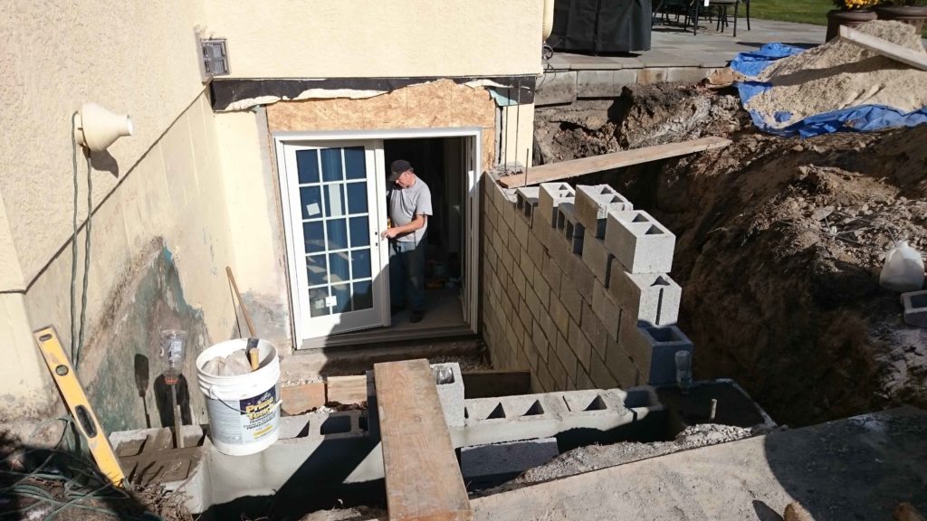 A worker is installing the Cleargress® lightweight doors for basement